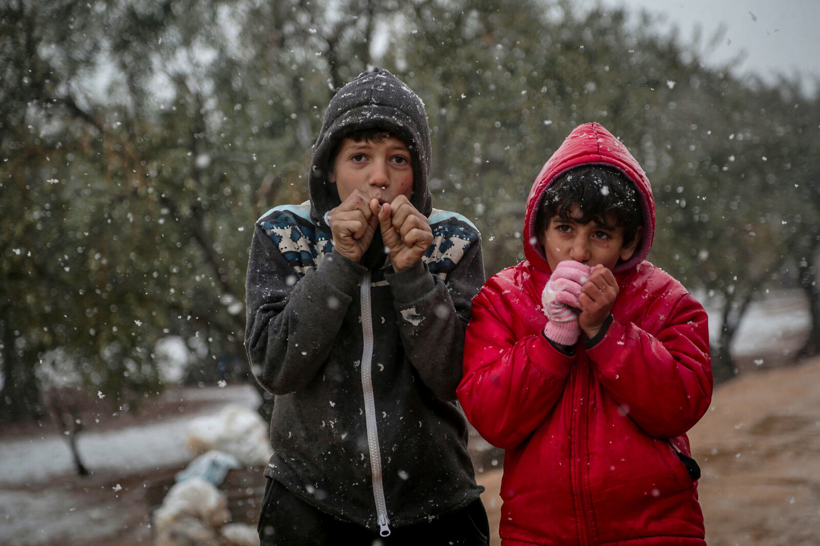 Kinder stehen in der Kälte im Schnee draussen