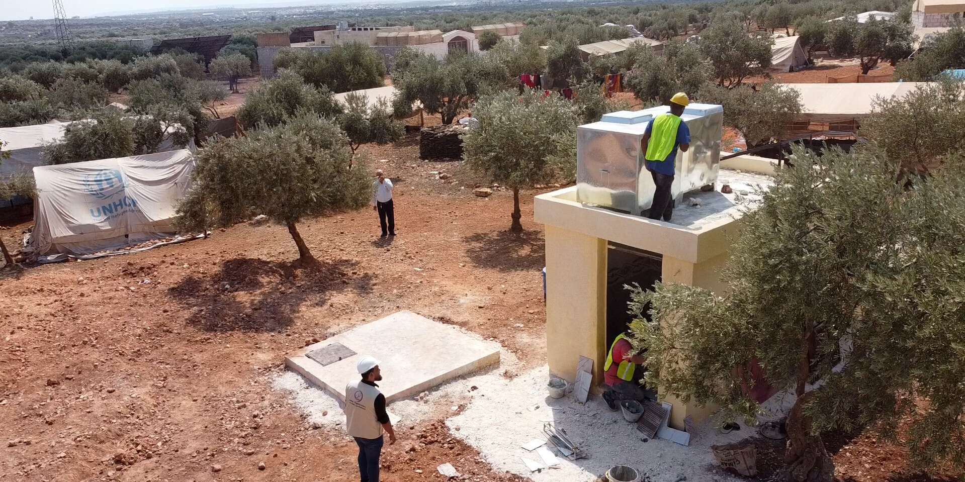 Helfer beim Bau einer Latrine in einem Flüchtlingscamp in Syrien