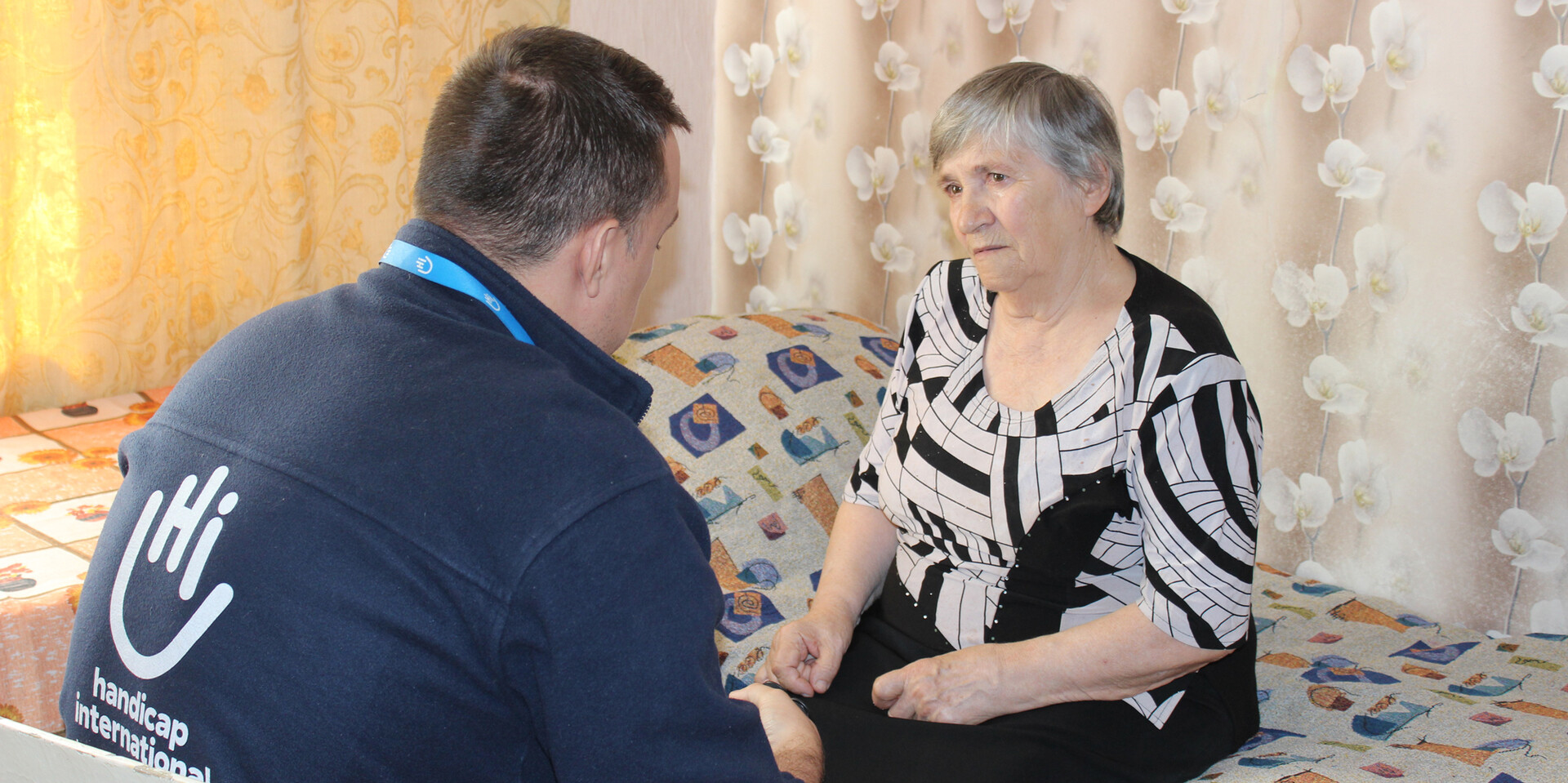 Lidiya mit einem Helfer von Handicap International