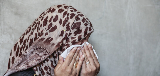 Frau trauert vor einer Wand in Aleppo, Syrien