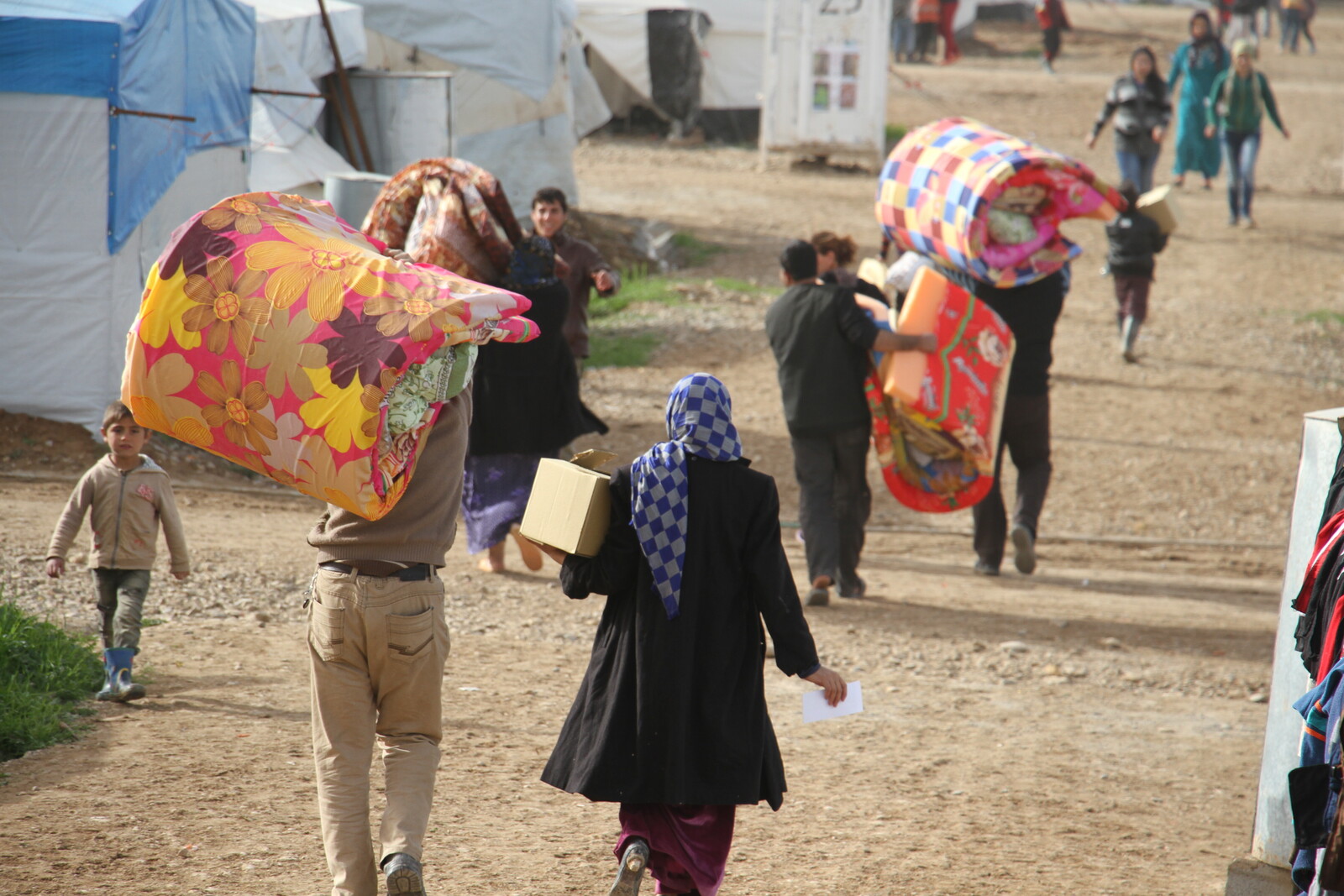 Menschen im Flüchtlingscamp werden mit Matratzen und Decken versorgt
