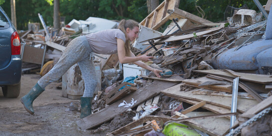 Eine Frau bei Aufräumarbeiten nach dem Hochwasser im Juli 2021