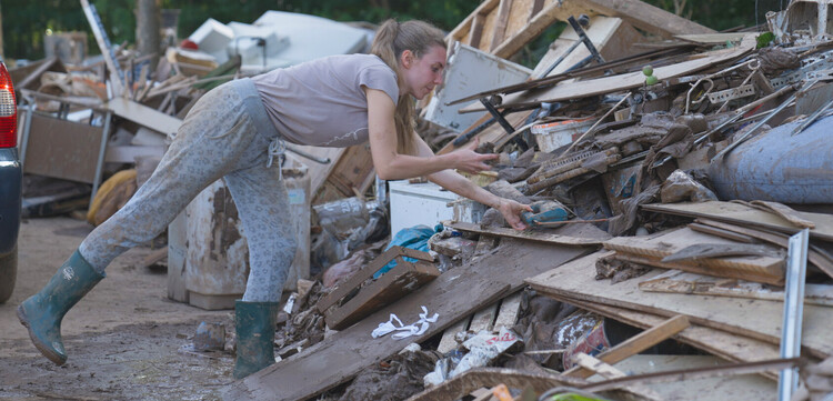 Eine Frau bei Aufräumarbeiten nach dem Hochwasser im Juli 2021