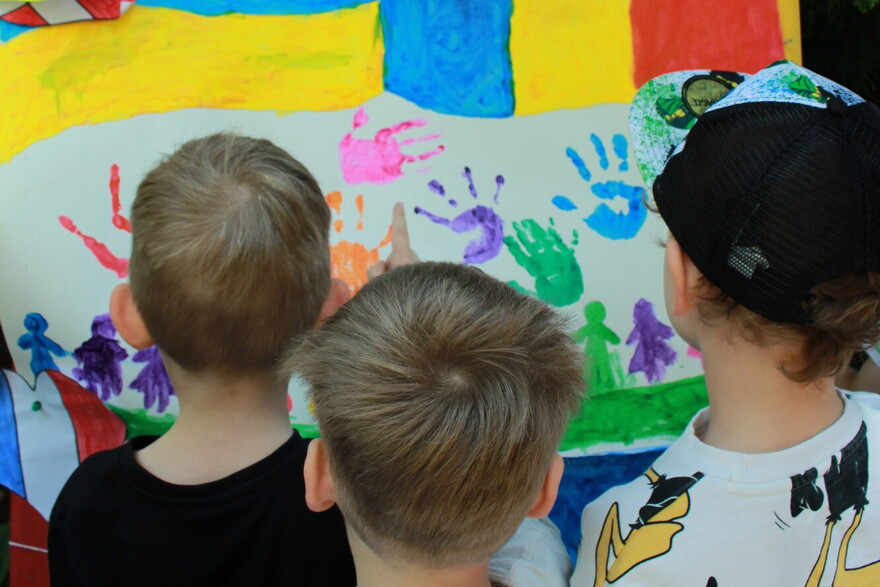 Drei Kinder beim Malen mit Fingerfarben Drei Kinder beim Malen mit Fingerfarben