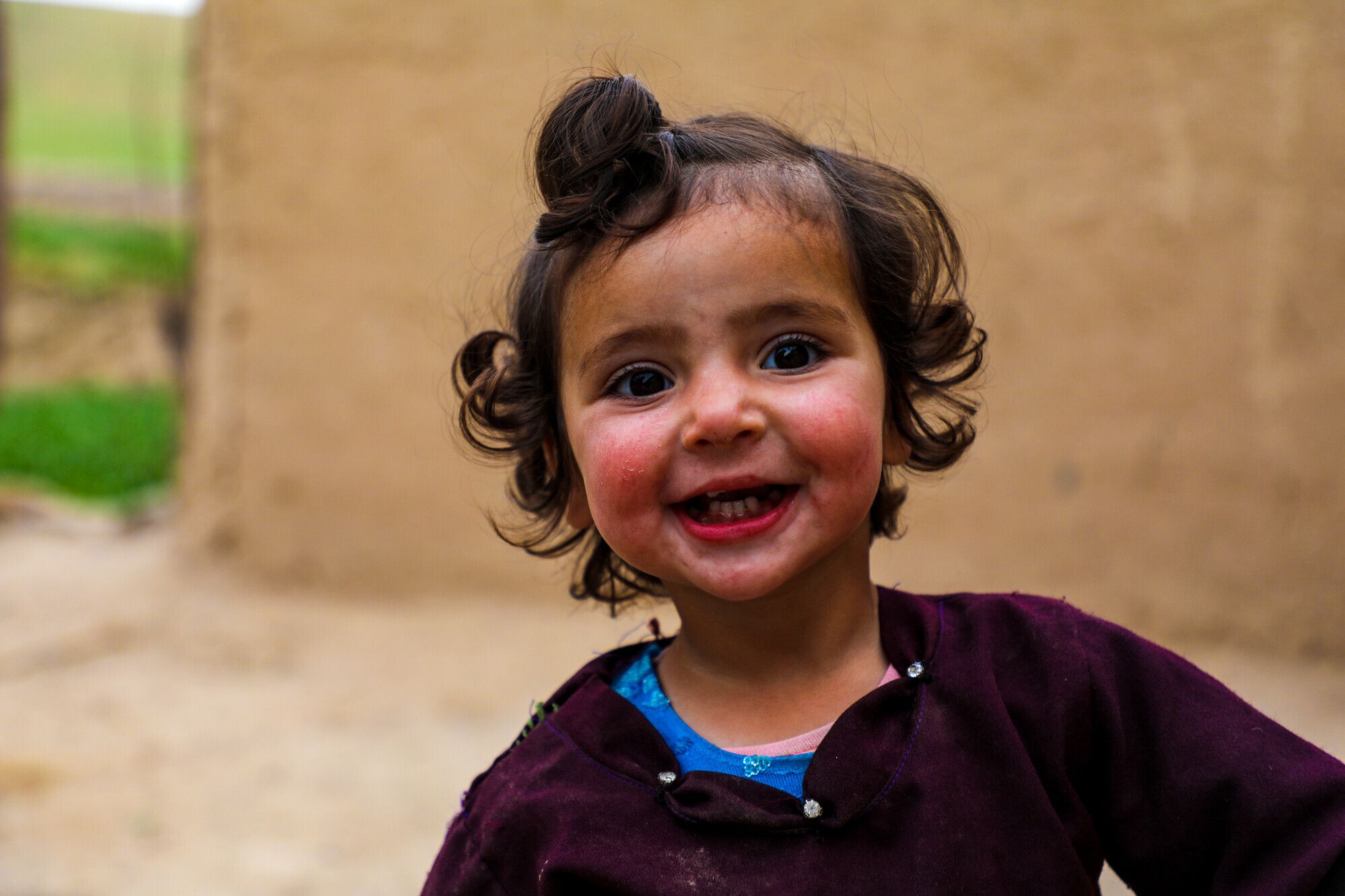 Ein kleines Mädchen in Afghanistan lächelt in die Kamera