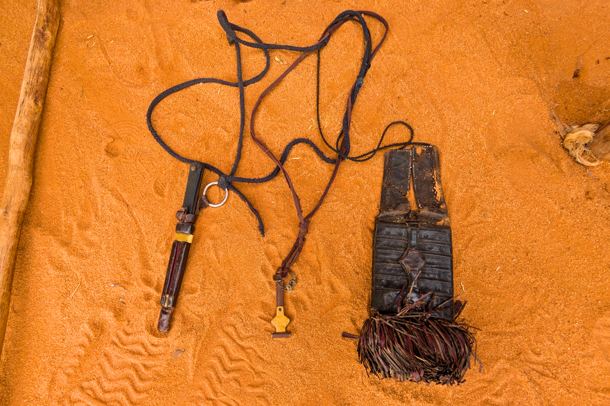 Drei Gegenstände, die um den Hals getragen werden können: ein in Leder gefasstes Messer, ein Behältnis zur Aufbewahrung einer Pinzette und eine Geldbörse in Form eines Talismans