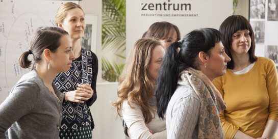 Frauen stehen vor einem Schild "Kompetenzzentrum".