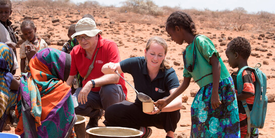 Zwei Mitarbeitende von der Hilfsorganisation Malteser International verteilen Essen in Kenia