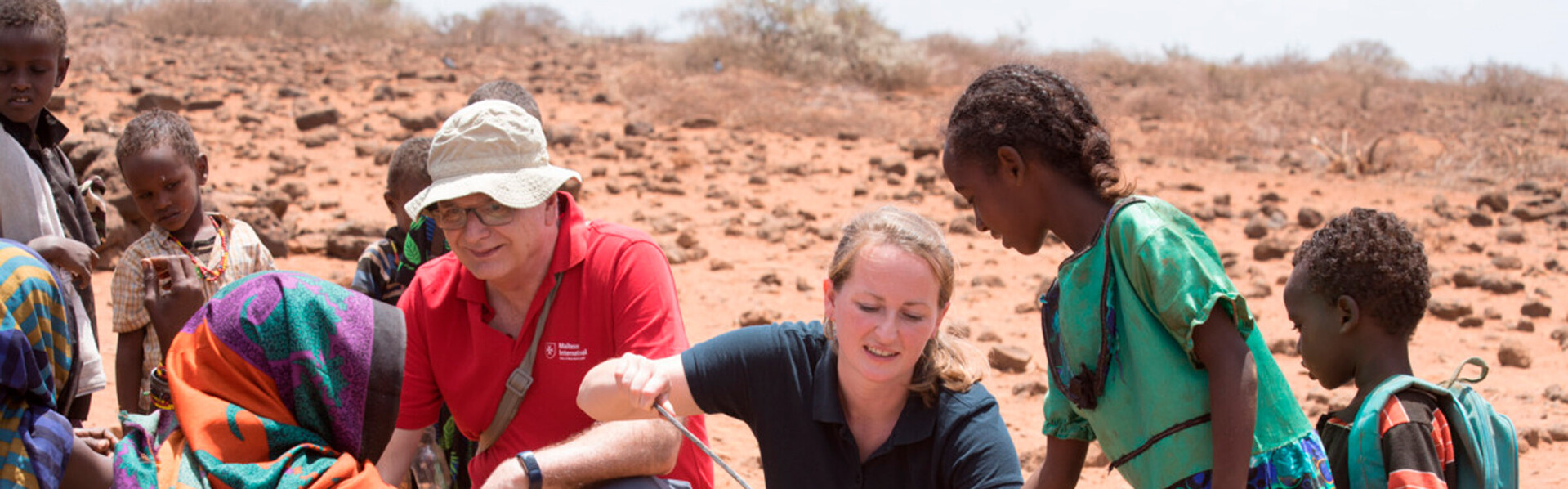 Zwei Mitarbeitende von der Hilfsorganisation Malteser International verteilen Essen in Kenia