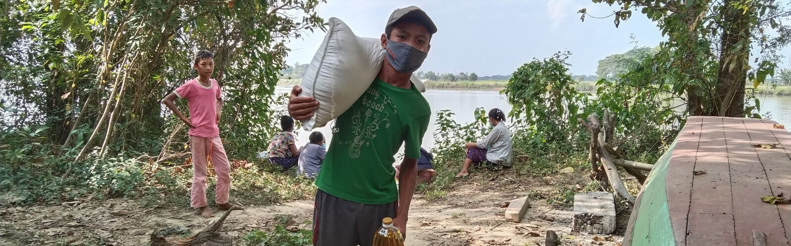 Ein Junge in Myanmar trägt einen Sack über der Schulter