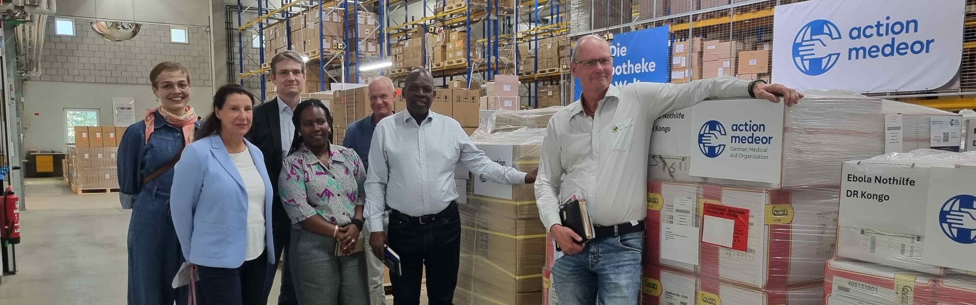 action medeor empfängt Besuch aus der DR Kongo Menschen stehen in einem Medikamentenlager