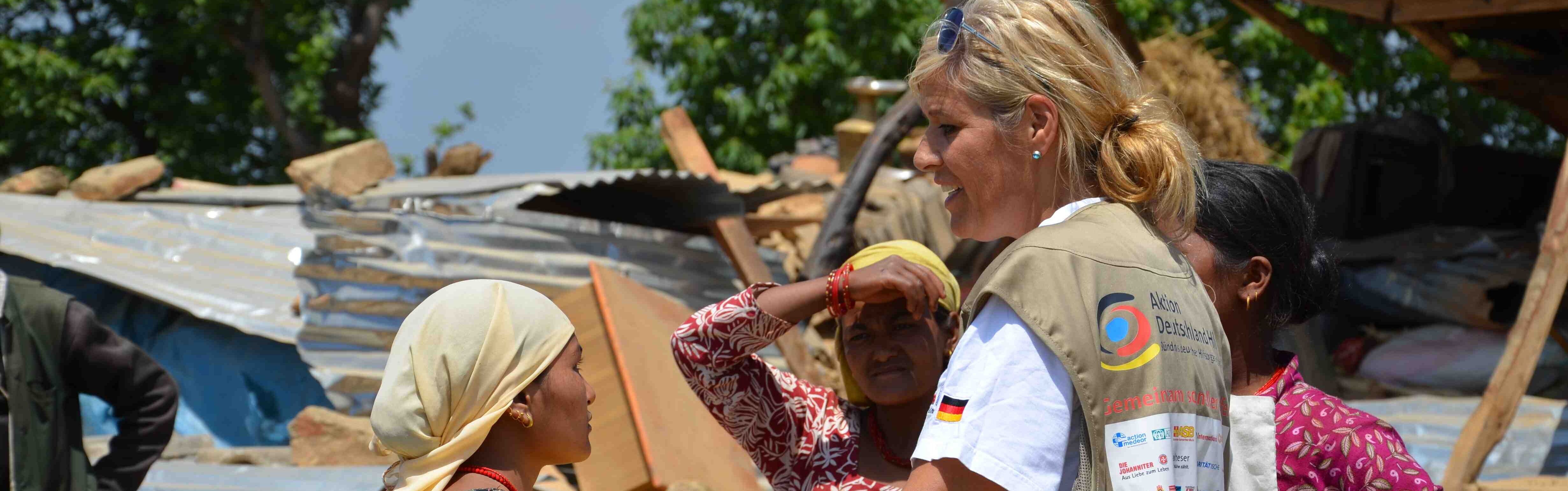 Eine Helferin von Aktion Deutschland Hilft spricht mit Frauen.