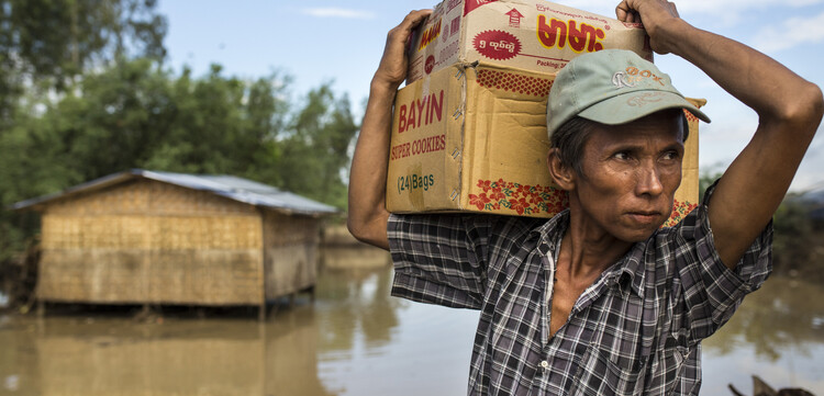 Ein Mann bringt sein Hab & Gut während des Hochwassers in Sicherheit