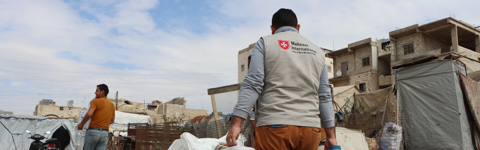 Helfer der Malteser nach dem Erdbeben in Syrien tragen Benzinkanister Helfer der Malteser nach dem Erdbeben in Syrien tragen Benzinkanister
