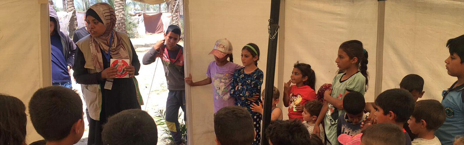 Mitarbeiterin von Handicap International (HI) mit Kindern in Gaza 