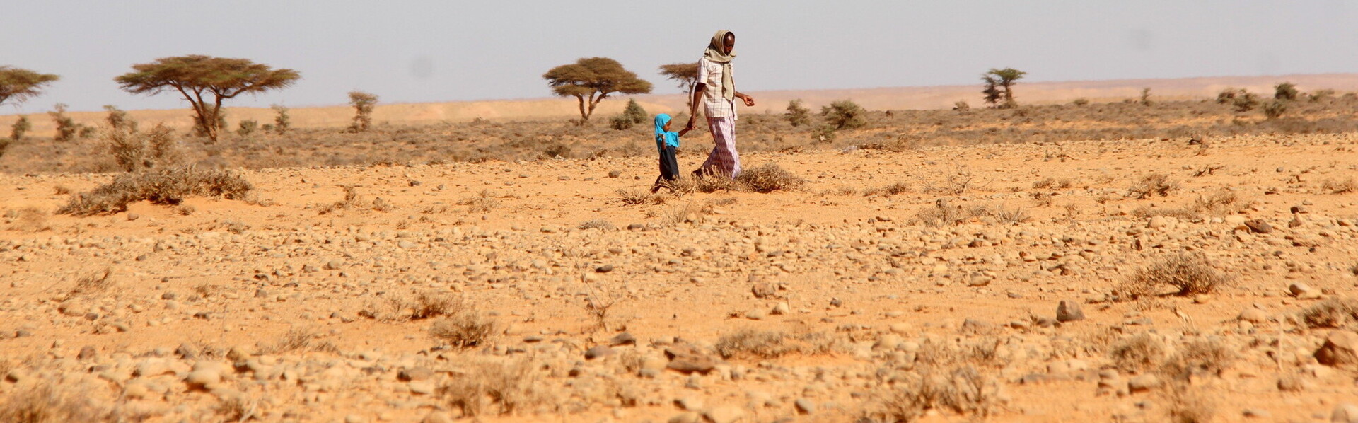 Eine Frau wandert mit ihrer Tochter durch eine ausgetrocknete Region in Somalia