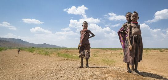 Kinder in Kenia stehen in einem trockenem Gebiet. Sie sind von der Hungerkrise in Afrika betroffen.
