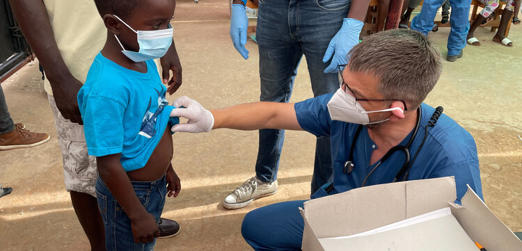 Ein Helfer des BRH untersucht ein Kind in Haiti Ein Helfer des BRH untersucht ein Kind in Haiti