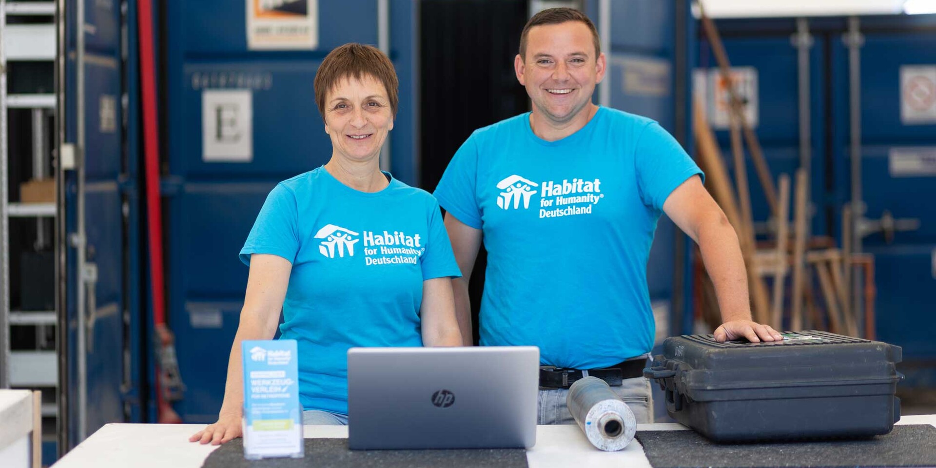Zwei Mitarbeitende beim Werkzeugverleih von Habitat for Humanity