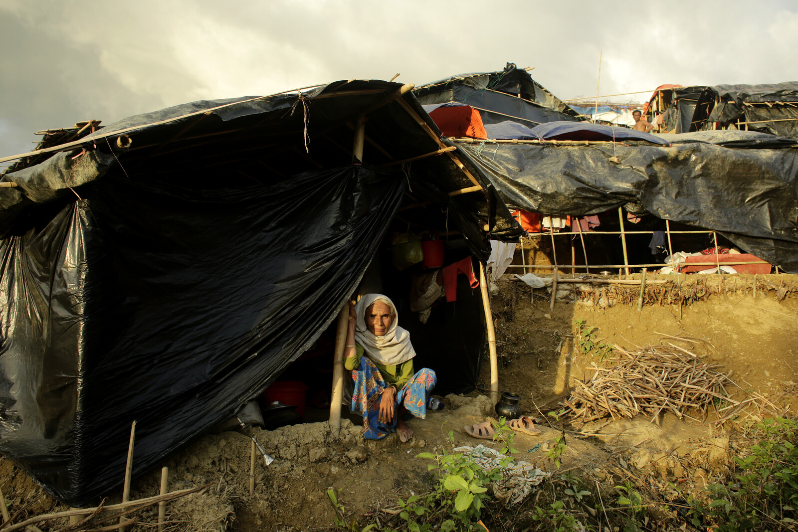Eine ältere Rohingya-Frau vor einer notdürftigen Unterkunft im Flüchtlingscamp in Bangladesch