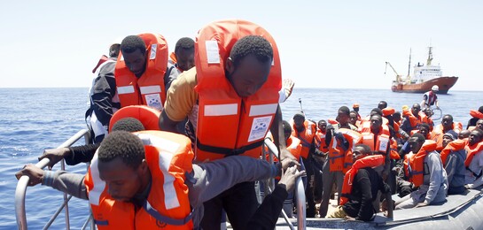 Flüchtlinge steigen auf ein Boot im Mittelmeer.