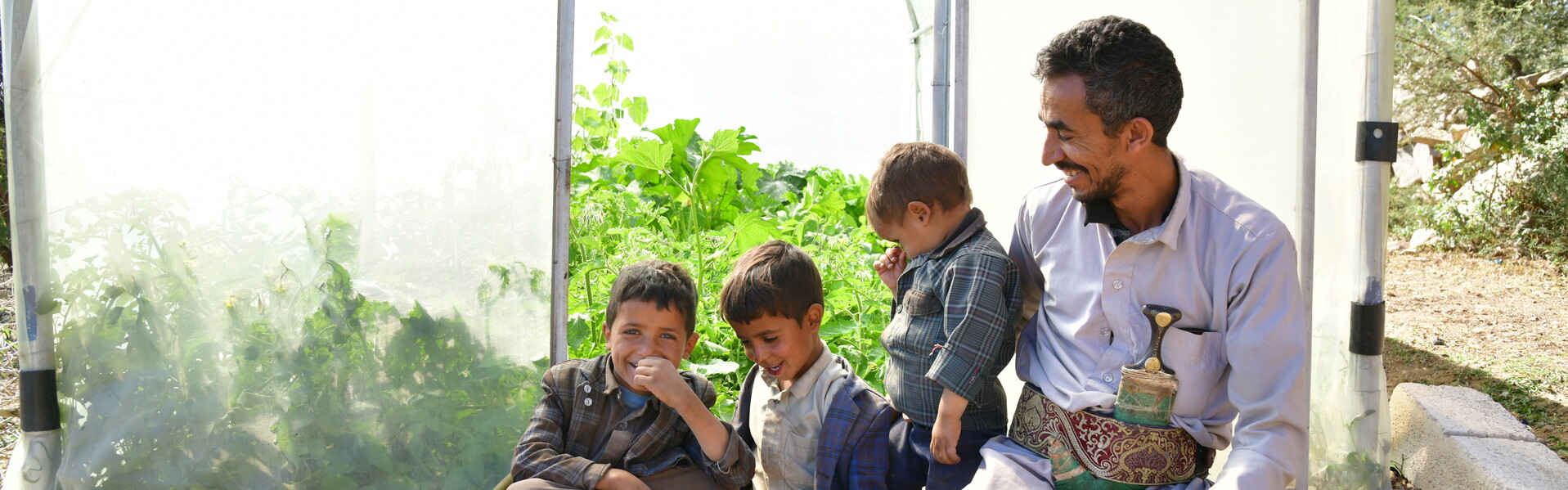 Sateq und seine drei Söhne freuen sich über das neue Gewächshaus