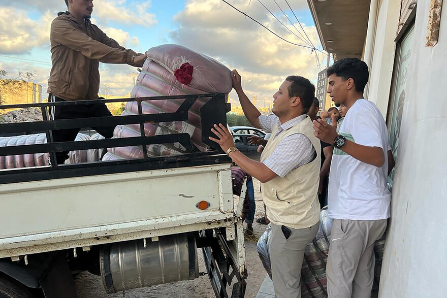 Drei Männer bei der Entladung von Hilfsgütern aus einem Truck in Libyen Drei Männer bei der Entladung von Hilfsgütern aus einem Truck in Libyen