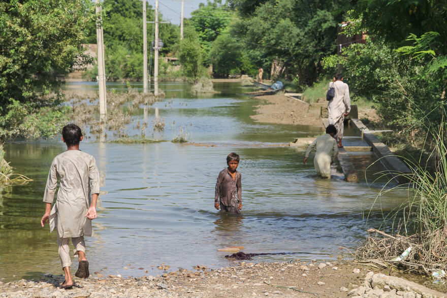 Kinder waten durch unterspülte Straßen Kinder waten durch unterspülte Straßen