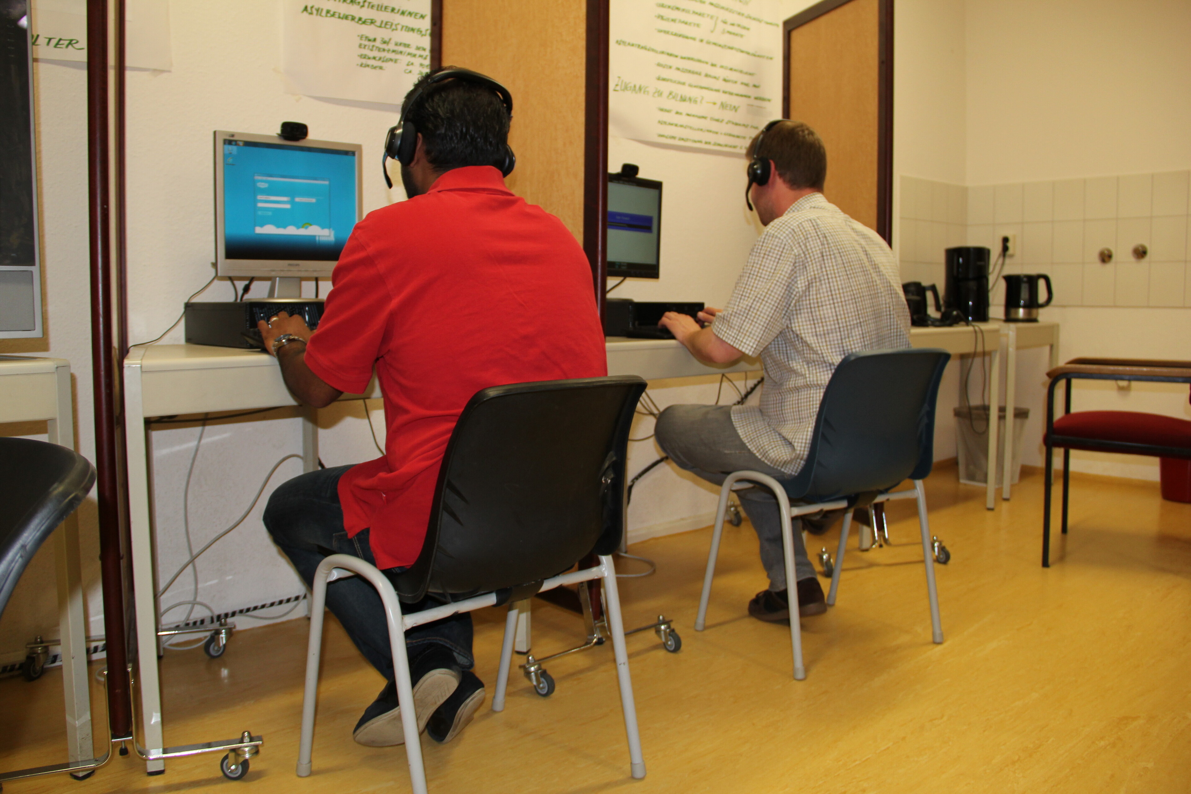 Zwei Menschen in einer Flüchtlingsunterkunft arbeiten an Computern (Archivbild) Zwei Menschen in einer Flüchtlingsunterkunft arbeiten an Computern (Archivbild)