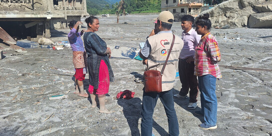 Helfer von AWO International unterhalten sich mit Betroffenen der Sturzflut in Nepal