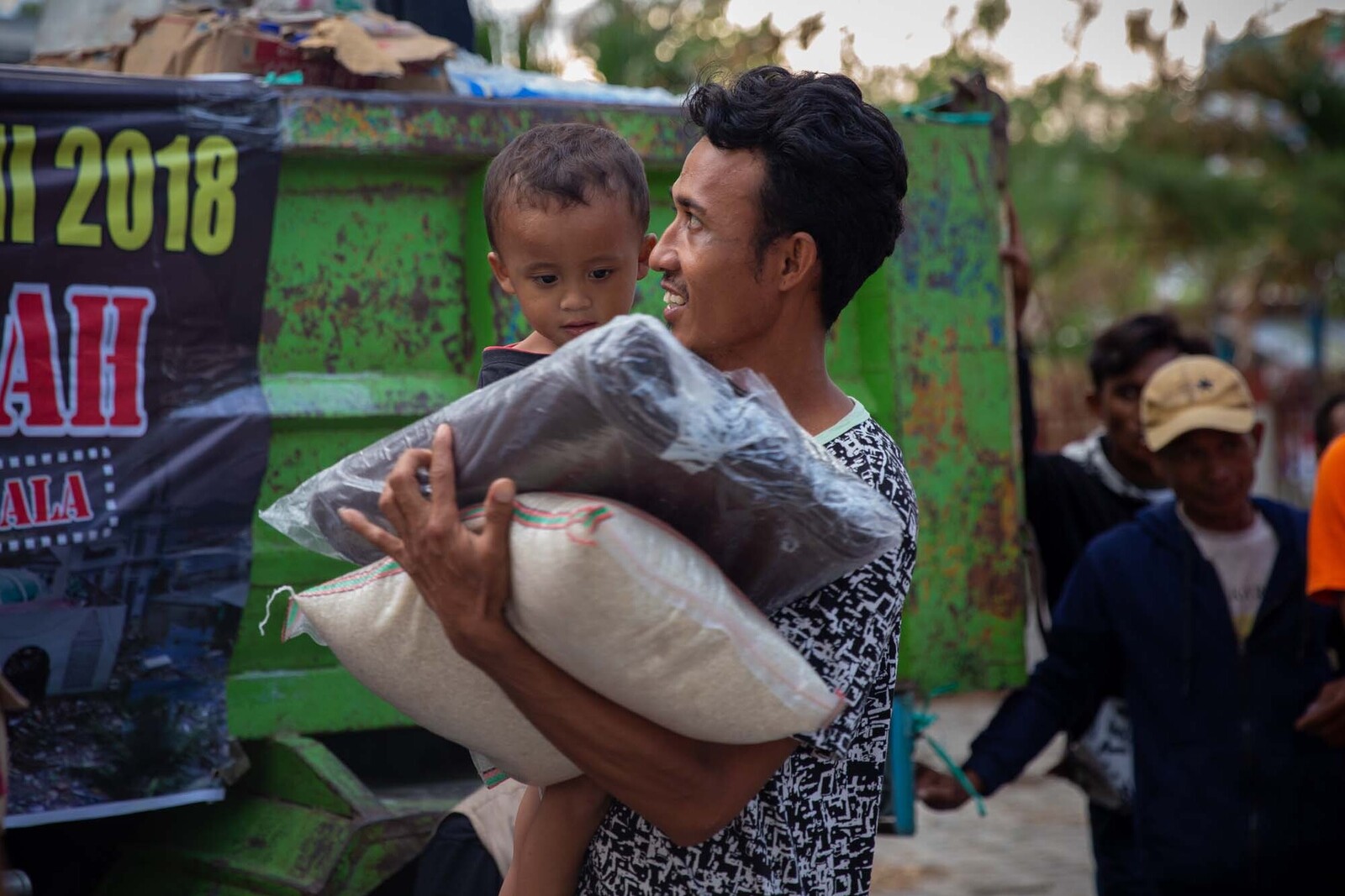Hoffnung nach der Katastrophe: Mann und Kind mit dringend benötigen Hilfsgütern