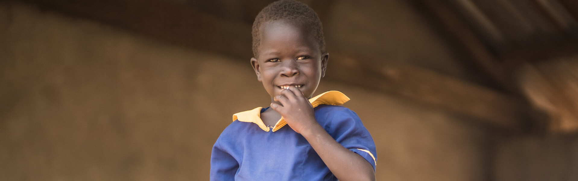 Ein Mädchen im Südsudan vor der Schule, in der sie eine Mahlzeit am Tag erhält