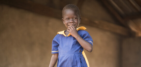 Ein Mädchen im Südsudan vor der Schule, in der sie eine Mahlzeit am Tag erhält