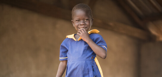 Ein Mädchen im Südsudan vor der Schule, in der sie eine Mahlzeit am Tag erhält