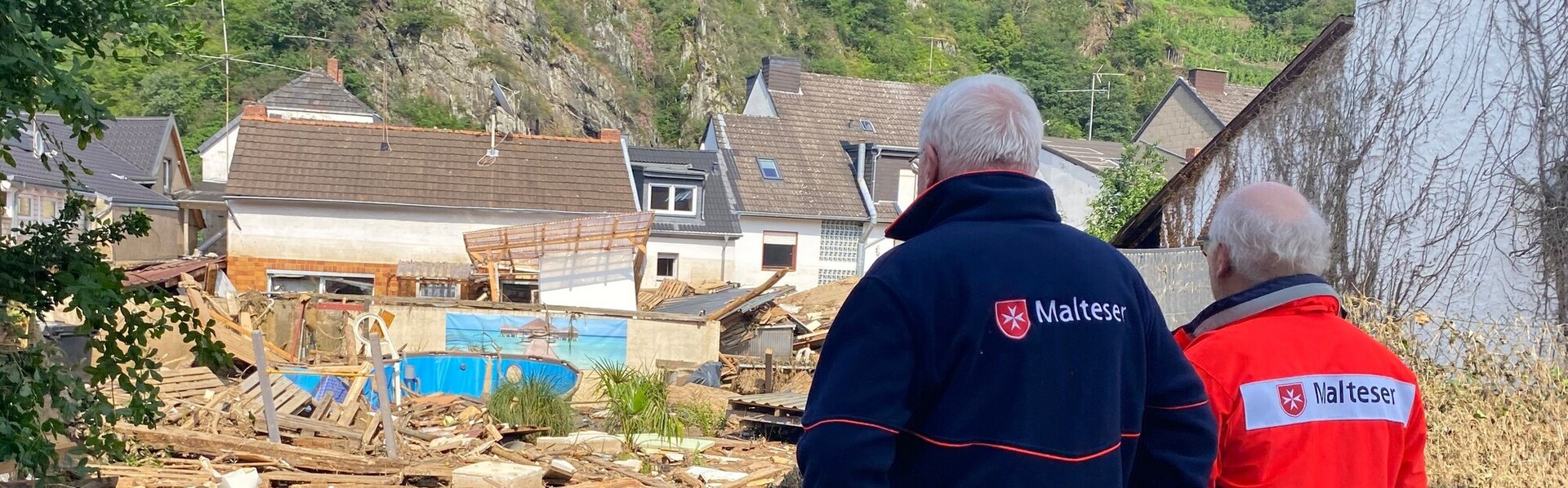 Helfer der Malteser blicken auf den von der Flut überschwemmten Ort Mayschoss im Ahrtal