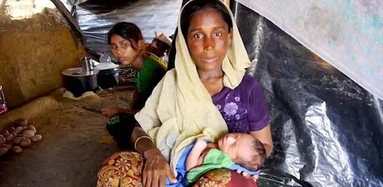 Eine Frau aus Myanmar mit ihrem Baby in einer Notunterkunft in Bangladesch
