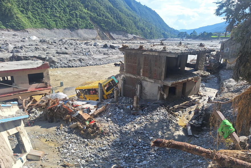 Zerstörte Gebäude und ein verschütteter Schulbus entlang des Flusses nach der Sturzflut in Nepal