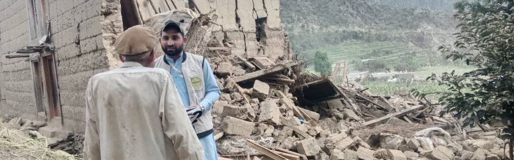 Männer in Afghanistan vor von Erdbeben zerstörten Häusern Männer in Afghanistan vor von Erdbeben zerstörten Häusern