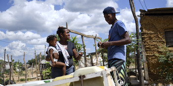 Eine Frau mit Kind aus Venezuela spricht mit einem Mann