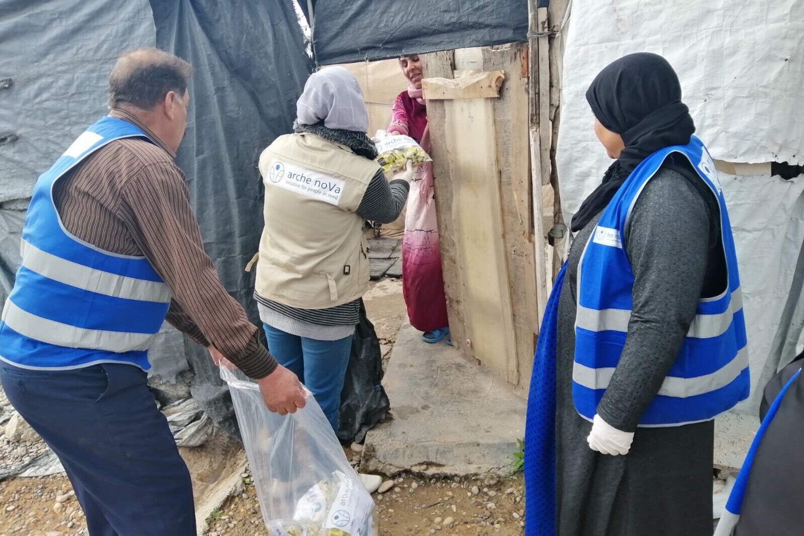 Helfer:innen versorgen Menschen in einem Flüchtlingscamp