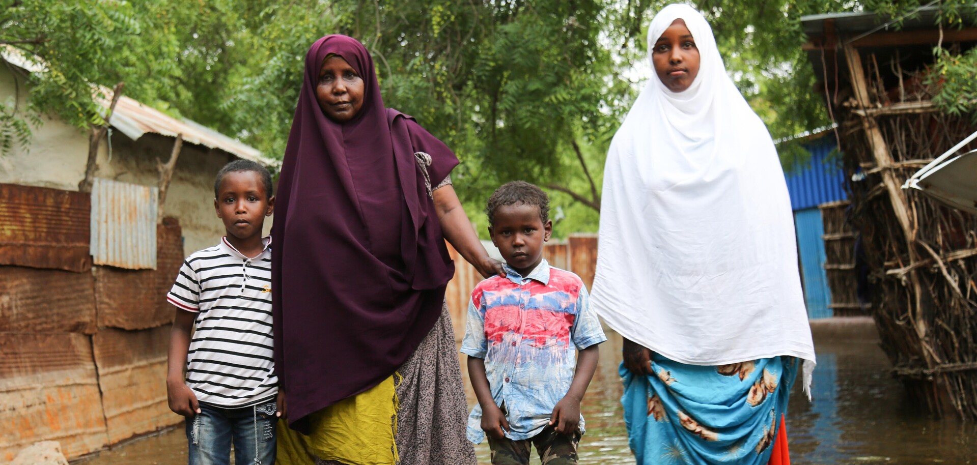 Familie steht vor überflutetem Haus in Somalia Familie steht vor überflutetem Haus in Somalia