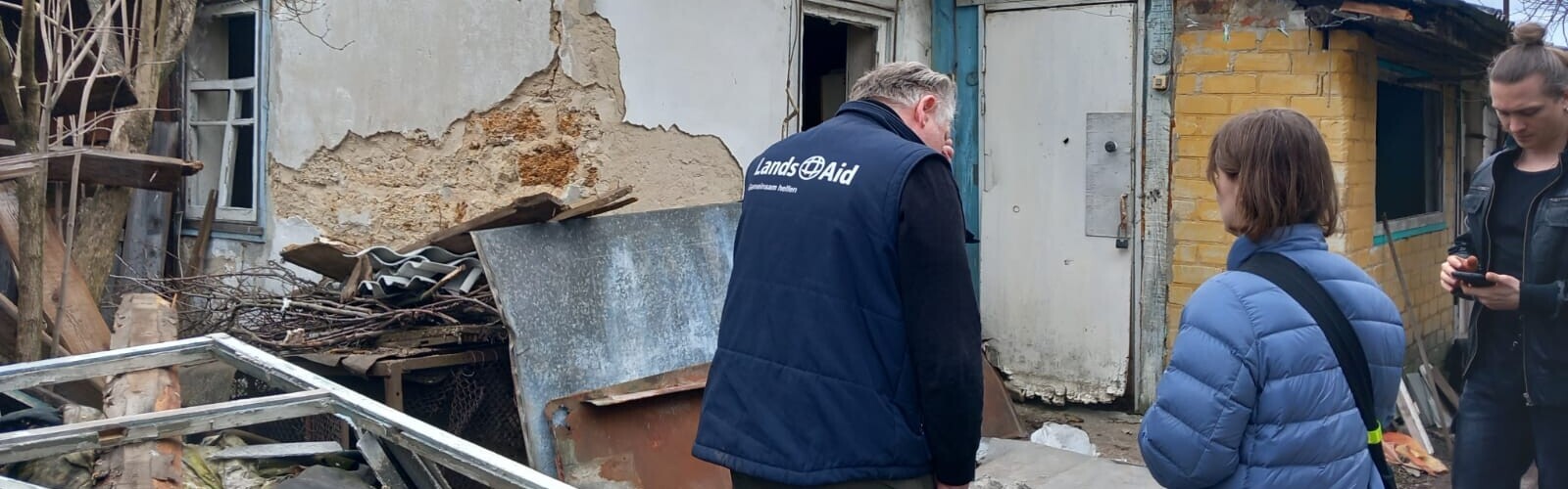 Ein Helfer von LandsAid besichtigt ein zerstörtes Haus in der Ukraine