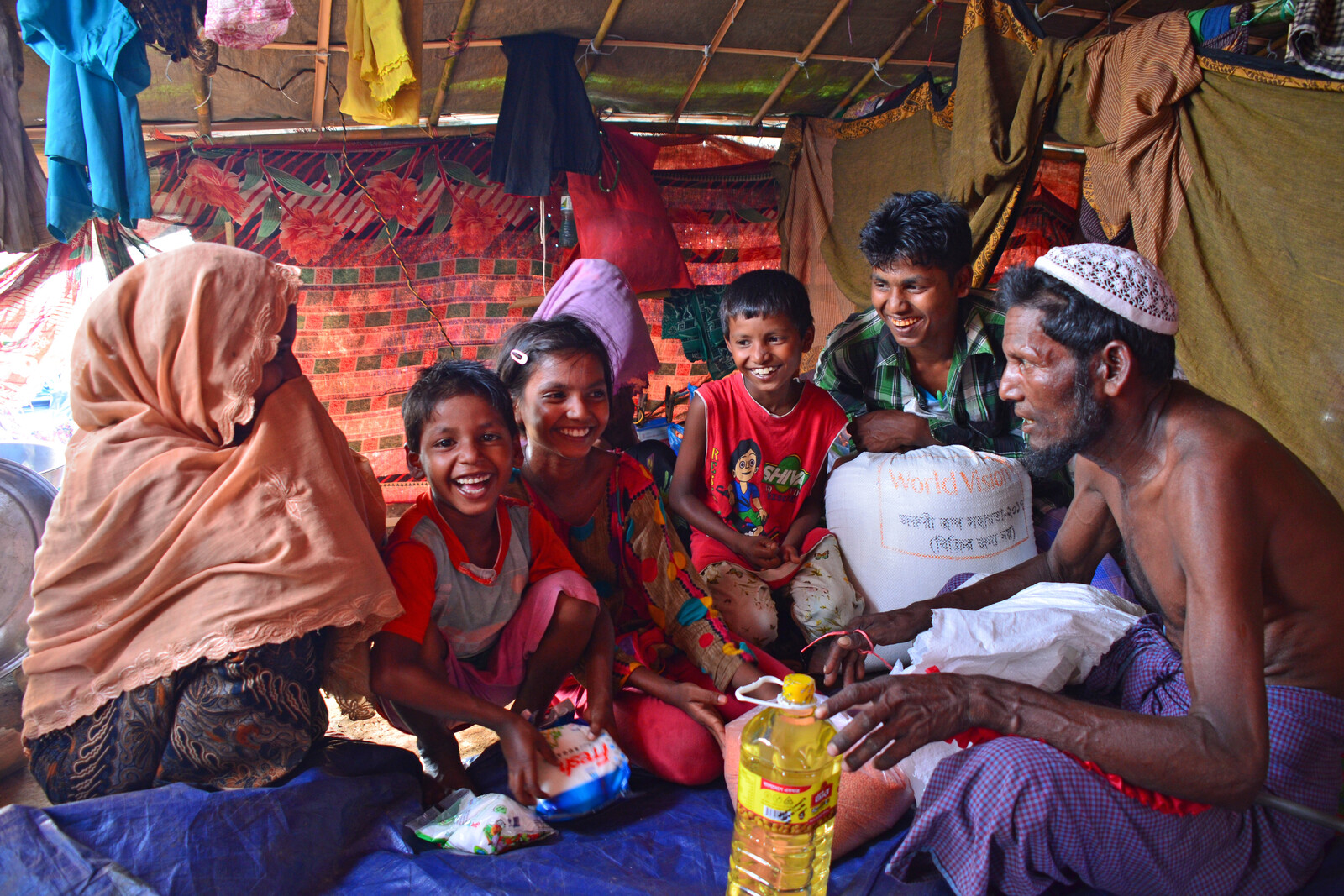 Eine Rohingya-Familie freut sich über die gespendeten Lebensmittel von World Vision