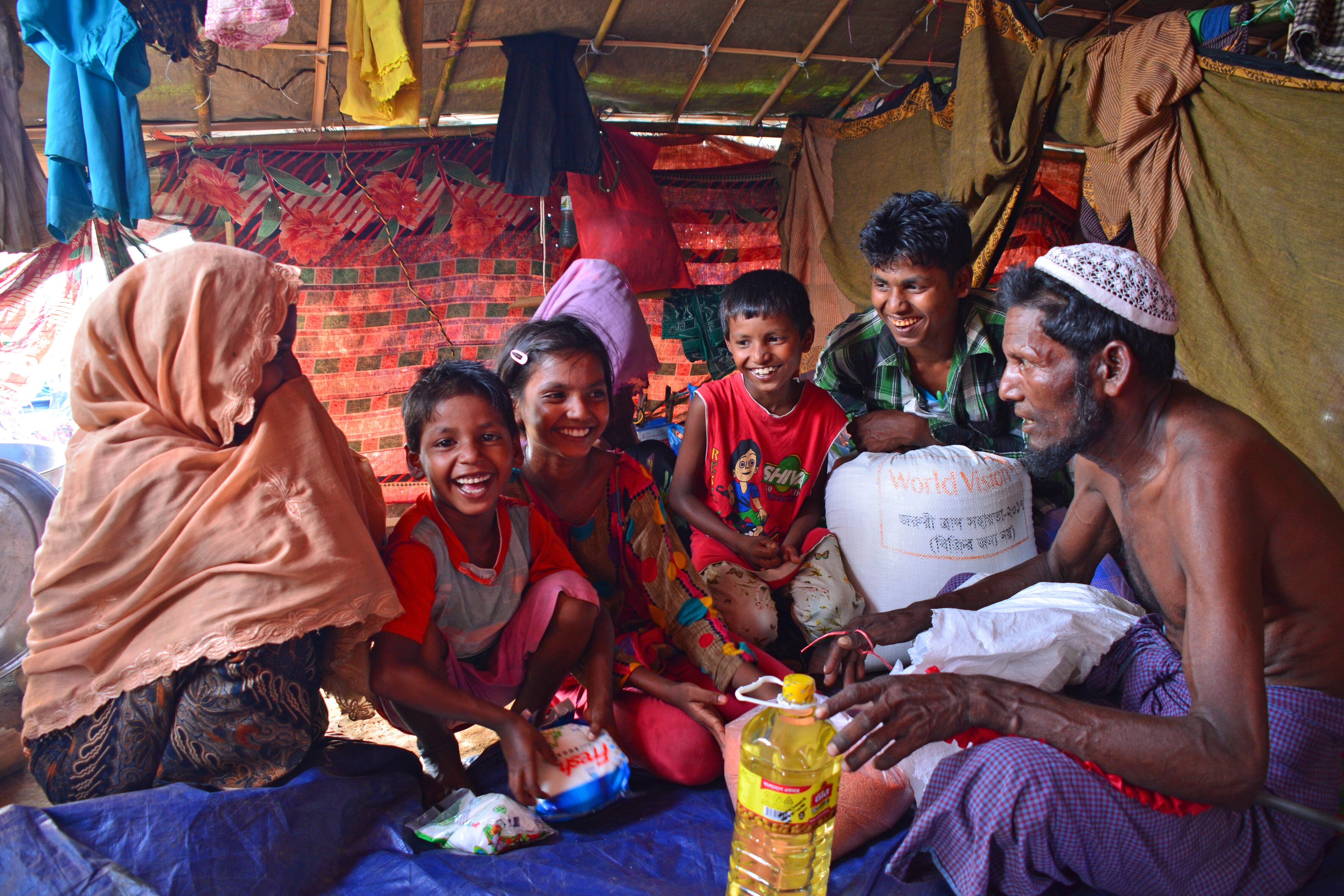 Eine Rohingya-Familie freut sich über die gespendeten Lebensmittel von World Vision Eine Rohingya-Familie freut sich über die gespendeten Lebensmittel von World Vision
