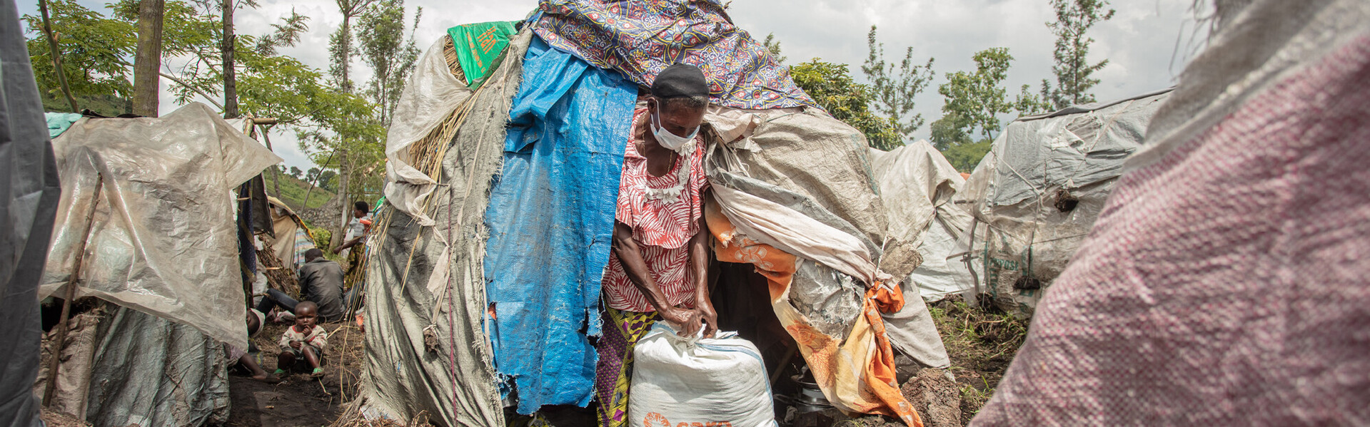 Madame Bora Kubuya in einem Camp in der DR Kongo mit ihrer Essensration, die sie von der Hilfsorganisation CARE erhalten hat