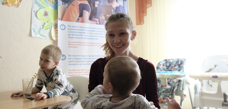 Eine Frau aus der Ukraine mit ihren Kindern bei einem Hilfsprojekt von World Vision
