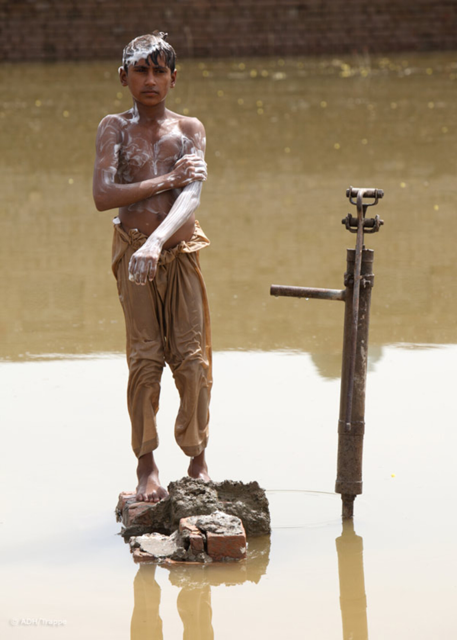 2010.08.30-junge-waescht-sich-an-pumpe2.JPG Flut Pakistan: Junge wäscht sich an einer Pumpe