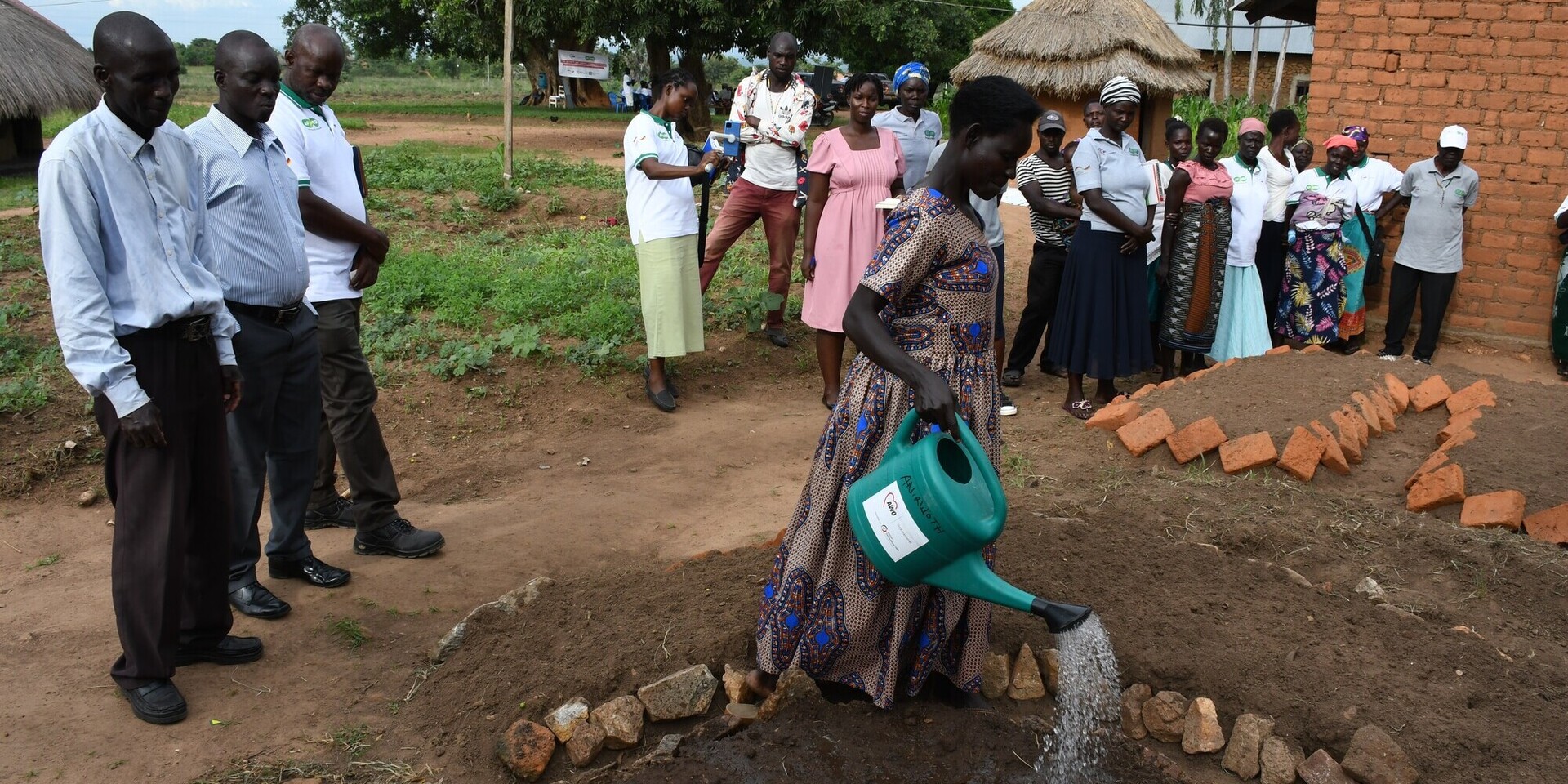 Eine Frau gießt ein Beet in einem Modelldorf in Uganda Eine Frau gießt ein Beet in einem Modelldorf in Uganda