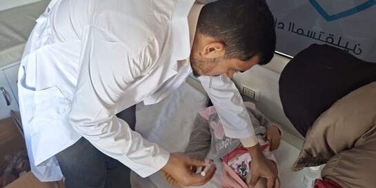 Ein Arzt behandelt ein Kleinkind in einer medizinischen Einrichtung am Grenzübergang zwischen Syrien und dem Libanon.