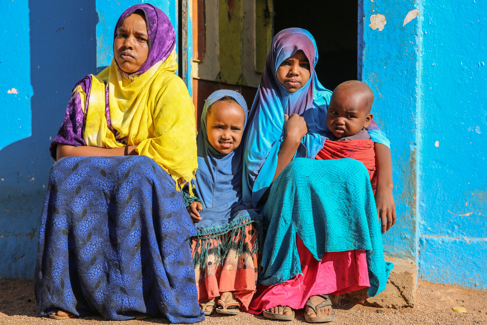 Eine Familie sitzt vor einem Haus in Somalia.
